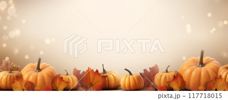 Pumpkins and Autumn Leaves on Beige Background with Bokeh Lights 117718015