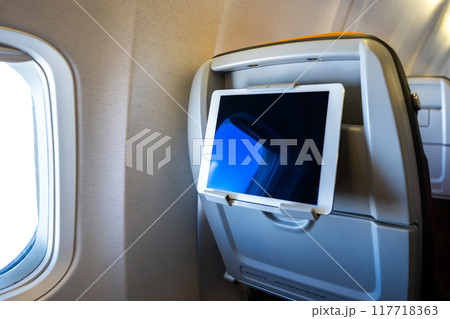 Using digital tablet in airplane for enertainment and work, no people 117718363