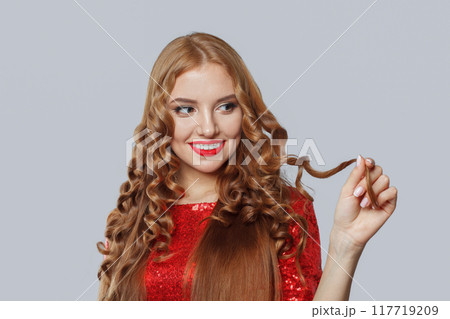 Pretty young adult model woman with long curly brown hairstyle posing 117719209