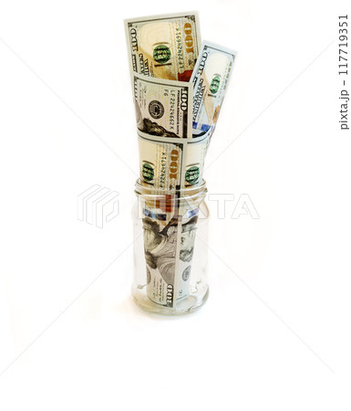 From glass banks stick banknotes. Money banknotes of US dollars inserted into a glass jar like a bouquet From glass banks stick banknotes. Money banknotes of US dollars inserted into a glass jar like a bouquet 117719351