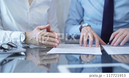 Diverse business people discussing contract papers before signing. Teamwork of lawyers are at work at the glass desk in office Diverse business people discussing contract papers before signing. Teamwork of lawyers are at work at the glass desk in office 117721953