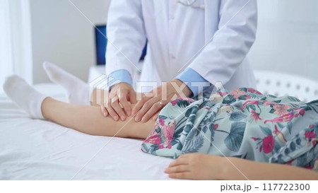 Doctor and kid patient. Orthopedist examining girl's knee in medical clinic. Medicine and health care Doctor and kid patient. Orthopedist examining girl's knee in medical clinic. Medicine and health care 117722300