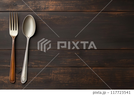 Fork and spoon placed on a wooden table 117723541