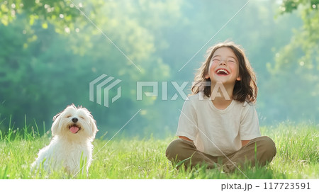 Child laughing with a dog in a sunny green park 117723591