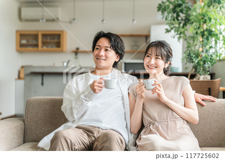 家のリビング・ソファでくつろぐ仲良しの若い日本人夫婦 117725602