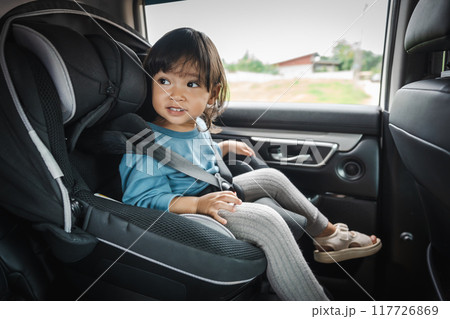 happy toddler girl sitting in car seat, safety baby chair travelling happy toddler girl sitting in car seat, safety baby chair travelling 117726869