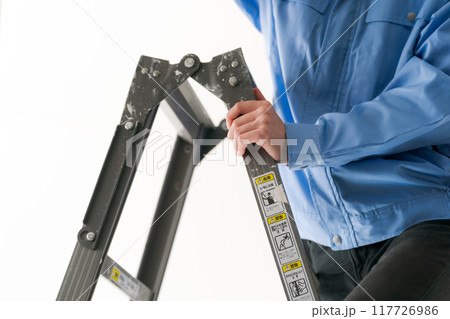 脚立に立つ作業員の男性の手元 117726986