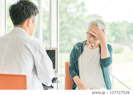 病院・介護施設で医師に病状を伝えるシニア女性と問診する男性医師(診療・診察・人間ドック・健康診断) 病院・介護施設で医師に病状を伝えるシニア女性と問診する男性医師(診療・診察・人間ドック・健康診断) 117727526