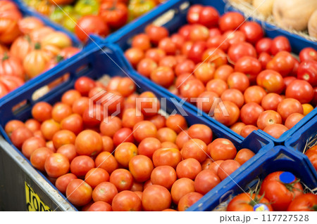 Pile of tomatoes lie on counter in shop 117727528