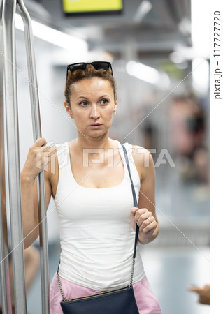 Adult woman stands in subway car 117727720