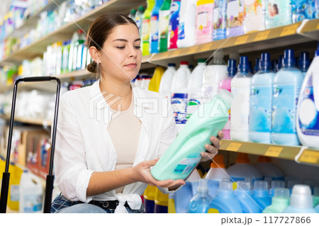 Girl looking for household detergents on shelves in store Girl looking for household detergents on shelves in store 117727866