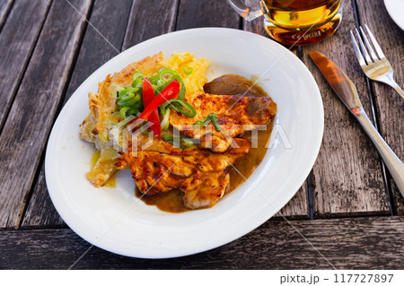 Chicken fillet served with baked potato 117727897
