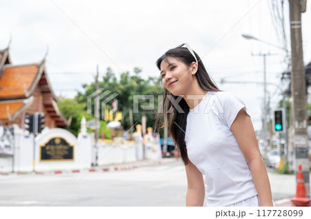 A beautiful Asian woman is waiting for a taxi by the street in the old town of Chiang Mai, Thailand. A beautiful Asian woman is waiting for a taxi by the street in the old town of Chiang Mai, Thailand. 117728099