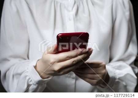 黒背景　スマホを持つ女性 117729114