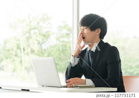 あくびをする若いビジネスマン あくびをする若いビジネスマン 117731171