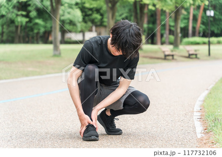 公園で運動中に足首を痛めた男性（痛風・捻挫・リハビリ・後遺症・関節） 117732106