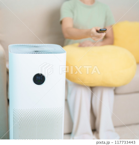 Air Purifier with woman relax on sofa. Purification system for filter and cleaning dust PM2.5 HEPA and virus in home. Allergy, Pure air, health, Wellness lifestyle and Air Pollution 117733443