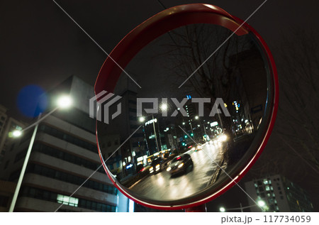 Round street mirror mounted at the crossing of urban roads, close-up Round street mirror mounted at the crossing of urban roads, close-up 117734059