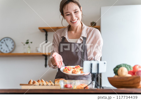 スマホでオンライン料理教室を配信する料理教室の講師の女性 スマホでオンライン料理教室を配信する料理教室の講師の女性 117734439