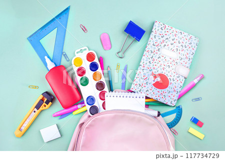 Back to school concept. School supplies are collected in a backpack. Pastel colors flat lay Back to school concept. School supplies are collected in a backpack. Pastel colors flat lay 117734729