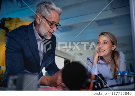 Two robotics engineers working on new project, standing in laboratory. Concept of modern technology in industries, automated processes, automotive 117735840