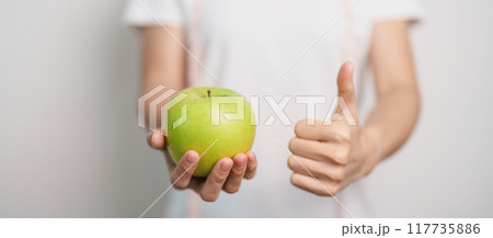 woman hand hold green Apple, happy female fitness choose fruit is Healthy food. Dieting control, Weight loss, Obesity, eating lifestyle and nutrition concepts 117735886