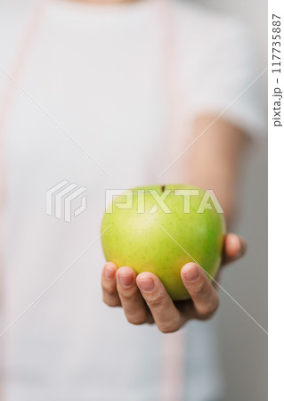 woman hand hold green Apple, happy female fitness choose fruit is Healthy food. Dieting control, Weight loss, Obesity, eating lifestyle and nutrition concepts woman hand hold green Apple, happy female fitness choose fruit is Healthy food. Dieting control, Weight loss, Obesity, eating lifestyle and nutrition concepts 117735887