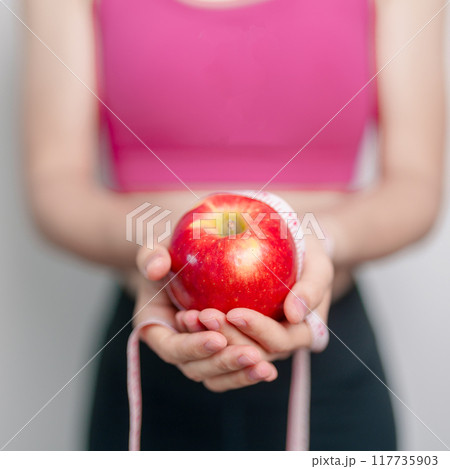 woman hand hold red Apple, happy female fitness choose fruit is Healthy food. Dieting control, Weight loss, Obesity, eating lifestyle and nutrition concepts 117735903