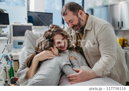 Father and daughter visiting mother in hospital after surgery. Emotional support from family for patients in hospital. 117736110
