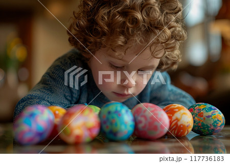 A young child is creatively adorning Easter eggs with vibrant colors.. A young child is creatively adorning Easter eggs with vibrant colors.. 117736183