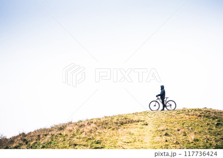Active man on bike in the middle of beautiful nature, early autumn morning. Concept of healthy lifestyle. 117736424
