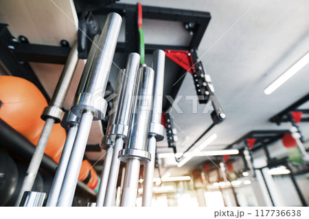 Metal bars, empty barbells in rack for strength training in gym. Metal bars, empty barbells in rack for strength training in gym. 117736638