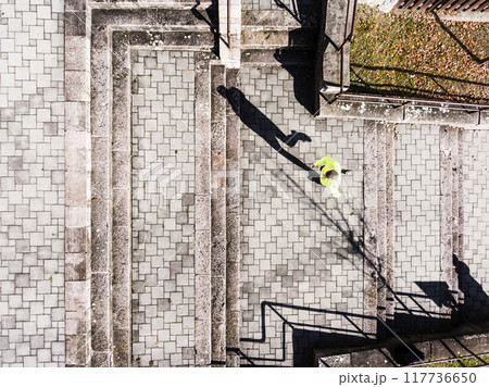 Aerial view of two runners running up the staris in the park. Morning running training for male friends. Aerial view of two runners running up the staris in the park. Morning running training for male friends. 117736650