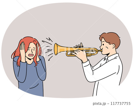 Man plays trumpet near woman covering ears, for concept trumpeter lack of musical talent Man plays trumpet near woman covering ears, for concept trumpeter lack of musical talent 117737755
