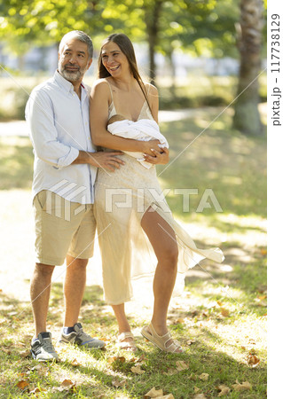 Happy family enjoying walk in park with newborn baby 117738129