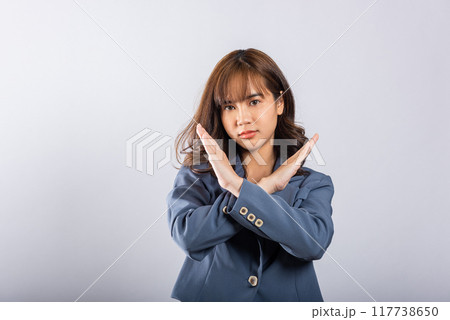 Portrait Asian beautiful young business woman unhappy or confident standing wear holding two cross arms say no X sign, studio shot isolated white background, Female pose reject gesture with copy space Portrait Asian beautiful young business woman unhappy or confident standing wear holding two cross arms say no X sign, studio shot isolated white background, Female pose reject gesture with copy space 117738650