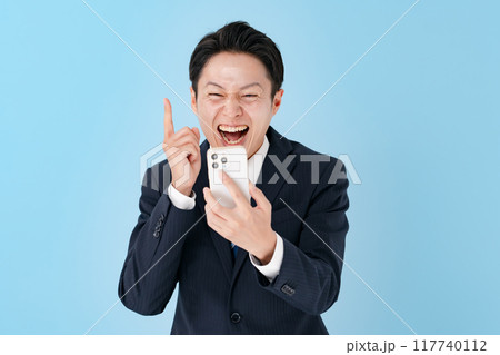スマホを持って驚くビジネスマン 117740112