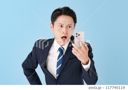 スマホを持って驚くビジネスマン スマホを持って驚くビジネスマン 117740119