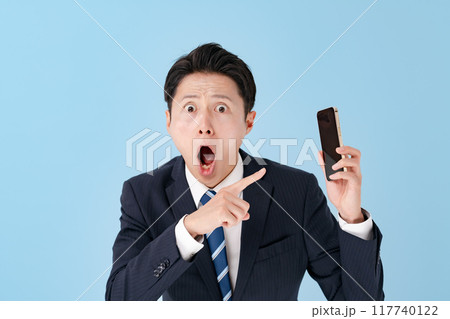 スマホを持って驚くビジネスマン スマホを持って驚くビジネスマン 117740122