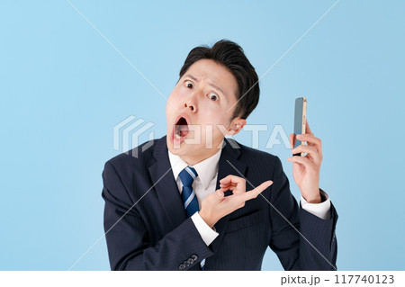 スマホを持って驚くビジネスマン スマホを持って驚くビジネスマン 117740123