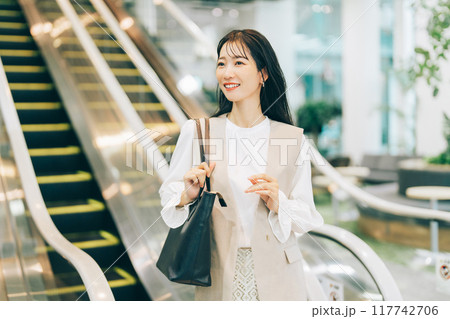 エスカレーターに乗る女性 117742706