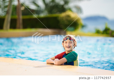 Kids jump into swimming pool. Summer water fun. Kids jump into swimming pool. Summer water fun. 117742937