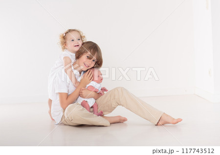 Siblings meet newborn baby 117743512