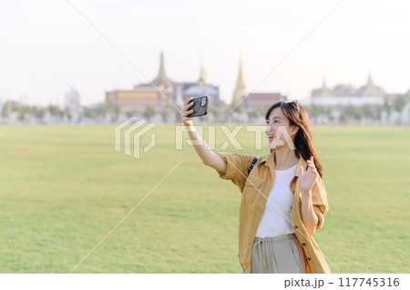 Traveler asian woman in her 30s explores the Grand Palace with a local guide. Uncover hidden gems and immerse yourself in Thai culture with her adventure. Traveler asian woman in her 30s explores the Grand Palace with a local guide. Uncover hidden gems and immerse yourself in Thai culture with her adventure. 117745316