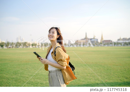 Traveler asian woman in her 30s explores the Grand Palace. Immerse yourself in the history, grandeur, and religious significance of this iconic landmark. Traveler asian woman in her 30s explores the Grand Palace. Immerse yourself in the history, grandeur, and religious significance of this iconic landmark. 117745318