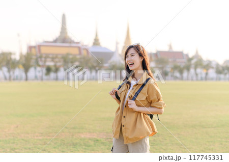 A Traveler Asian woman in her 30s exploring Wat Pra Kaew. From stunning architecture to friendly locals, she cherishes every moment, capturing it all in her heart and camera for years to come. 117745331
