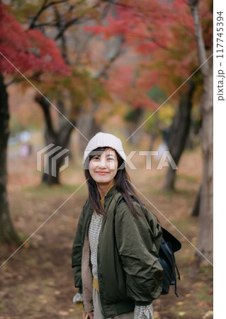Portrait of a young Asian woman with autumn leaves 117745394