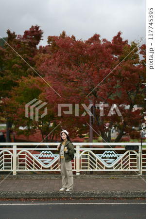 Portrait of a young Asian woman with autumn leaves 117745395
