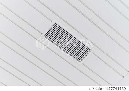 Ceiling mounted cassette type air conditioner and modern lamp light on a white ceiling. duct air conditioner for office or home Ceiling mounted cassette type air conditioner and modern lamp light on a white ceiling. duct air conditioner for office or home 117745580