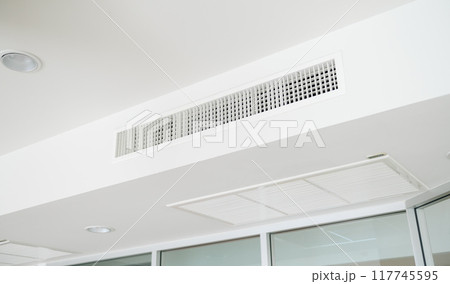 Ceiling mounted cassette type air conditioner and modern lamp light on white ceiling. duct air conditioner for home or office Ceiling mounted cassette type air conditioner and modern lamp light on white ceiling. duct air conditioner for home or office 117745595